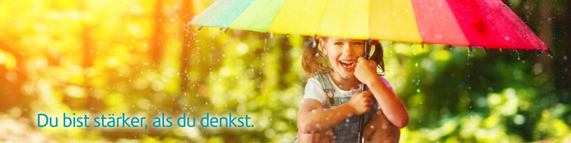 Happy child girl laughs and plays under the summer rain with an umbrella